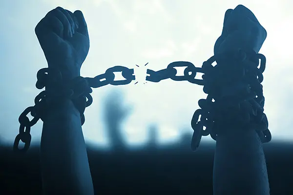 hands in chains with the chains breaking
