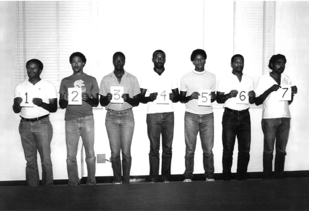 7 men standing side by side holding numbers 1-7