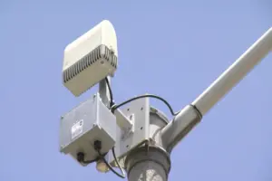 shotspotter detector on a pole against a blue sky