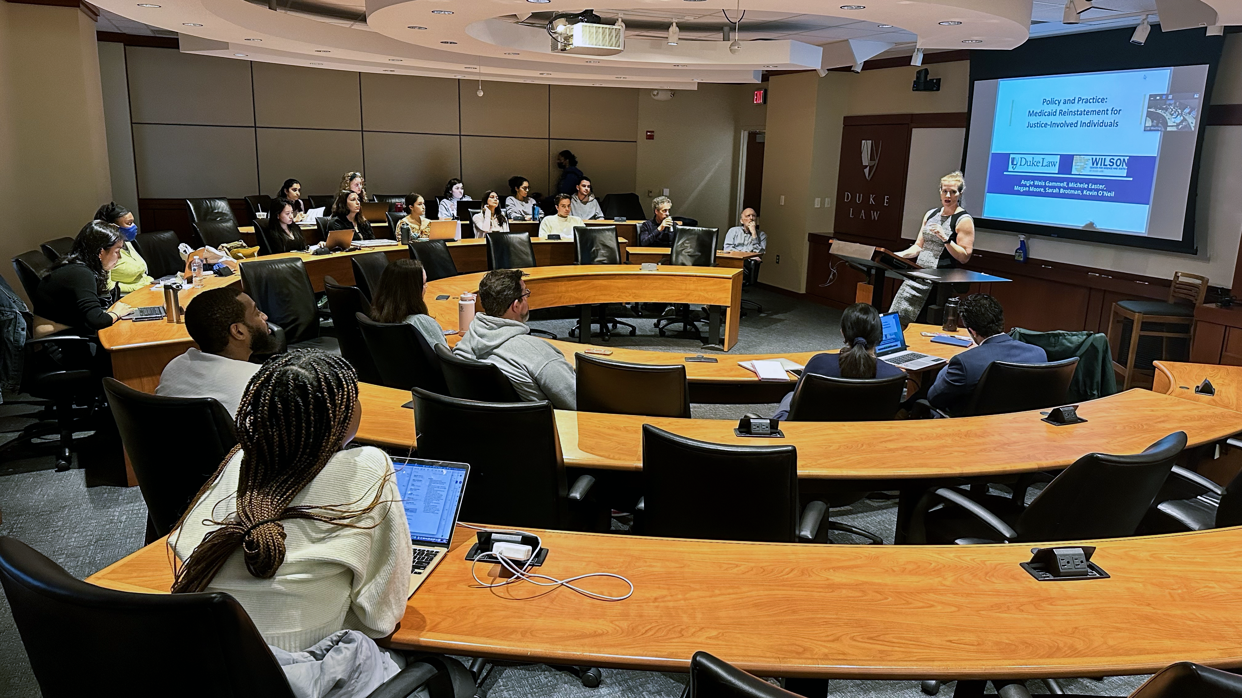 Woman presenting in front of a group of students in a classroom