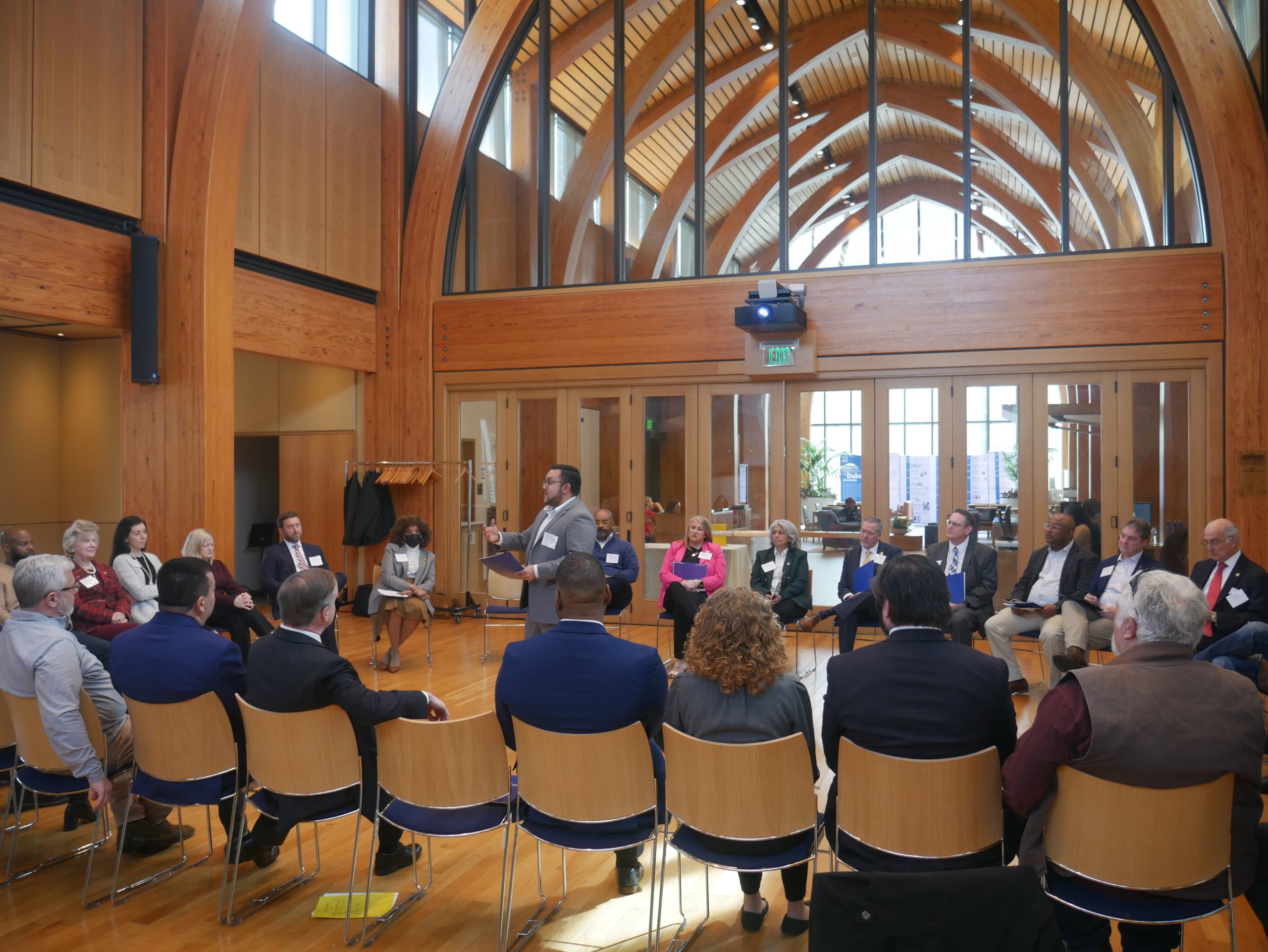 a group of people in a circle looking at a speaker