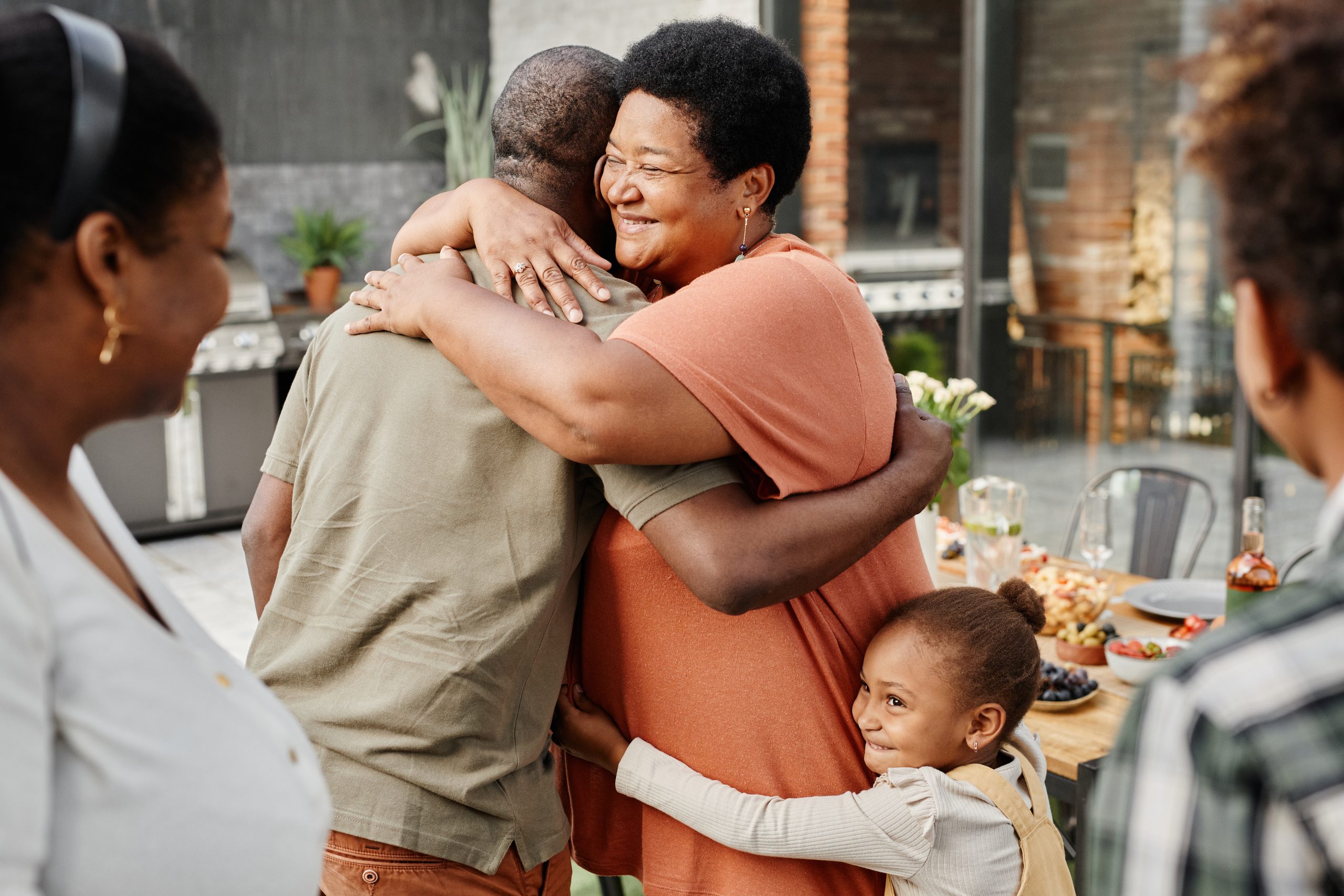 Woman embracing man while a little girl embraces her